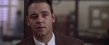 Movie still from “L.A. Confidential” (1997), directed by Curtis Hanson – A person wearing a suit and tie; Close Up shot, Over the shoulder angle