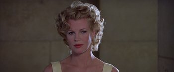 Movie still from “L.A. Confidential” (1997), directed by Curtis Hanson – A beautiful woman with blonde hair wearing a white dress; Close Up shot, Low angle