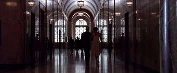 Movie still from “L.A. Confidential” (1997), directed by Curtis Hanson – Two people are walking in a hallway of a building; Extreme Wide shot, Low angle