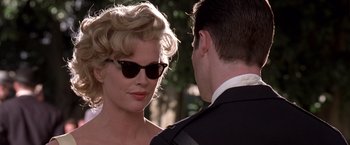 Movie still from “L.A. Confidential” (1997), directed by Curtis Hanson – A man and a woman wearing sunglasses and looking at one another; Close Up shot, Low angle
