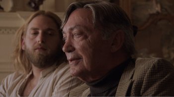Movie still from “Don't Worry, He Won't Get Far on Foot” (2018), directed by Gus Van Sant – A man sitting next to another man in a room; Close Up shot, Over the shoulder angle