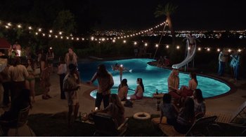 Movie still from “Don't Worry, He Won't Get Far on Foot” (2018), directed by Gus Van Sant – A group of people standing around a pool at night; Extreme Wide shot, High angle