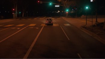 Movie still from “Don't Worry, He Won't Get Far on Foot” (2018), directed by Gus Van Sant – A car is stopped at a red light at night; Extreme Wide shot, High angle