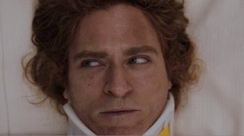 Movie still from “Don't Worry, He Won't Get Far on Foot” (2018), directed by Gus Van Sant – A person wearing a white shirt; Close Up shot, Overhead angle