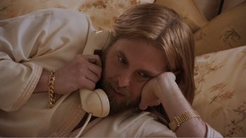 Movie still from “Don't Worry, He Won't Get Far on Foot” (2018), directed by Gus Van Sant – A man with long hair and a long beard talking on a phone; Close Up shot, High angle