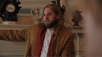 Movie still from “Don't Worry, He Won't Get Far on Foot” (2018), directed by Gus Van Sant – A man with long hair and a beard wearing a brown jacket; Medium shot, Over the shoulder angle