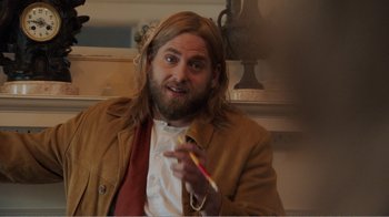 Movie still from “Don't Worry, He Won't Get Far on Foot” (2018), directed by Gus Van Sant – A man with long blond hair is holding a toothbrush; Medium shot, Over the shoulder angle