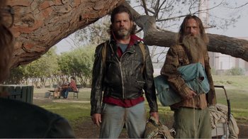 Movie still from “Don't Worry, He Won't Get Far on Foot” (2018), directed by Gus Van Sant – A man in a leather jacket standing next to a tree; Medium shot, Low angle