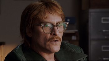 Movie still from “Don't Worry, He Won't Get Far on Foot” (2018), directed by Gus Van Sant – A person wearing glasses and a green jacket; Close Up shot, Low angle