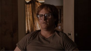 Movie still from “Don't Worry, He Won't Get Far on Foot” (2018), directed by Gus Van Sant – A person wearing glasses and a brown shirt; Close Up shot, Low angle