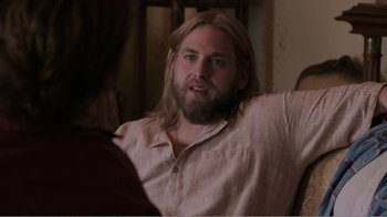 Movie still from “Don't Worry, He Won't Get Far on Foot” (2018), directed by Gus Van Sant – A man with long hair and a long beard is talking to a woman; Medium shot, Over the shoulder angle