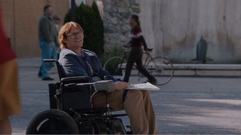 Movie still from “Don't Worry, He Won't Get Far on Foot” (2018), directed by Gus Van Sant – A person in a wheelchair on the sidewalk; Wide shot, High angle