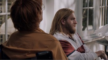 Movie still from “Don't Worry, He Won't Get Far on Foot” (2018), directed by Gus Van Sant – A man with long hair sitting next to a woman; Medium shot, Over the shoulder angle