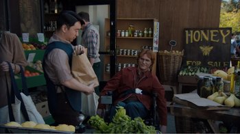 Movie still from “Don't Worry, He Won't Get Far on Foot” (2018), directed by Gus Van Sant – A man sitting at a table with a bag of food; Medium shot, Over the shoulder angle