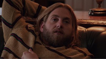 Movie still from “Don't Worry, He Won't Get Far on Foot” (2018), directed by Gus Van Sant – A man with a beard laying on a blanket; Medium shot, Over the shoulder angle