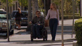 Movie still from “Don't Worry, He Won't Get Far on Foot” (2018), directed by Gus Van Sant – A man sitting in a wheel chair next to a woman; Wide shot, Over the shoulder angle