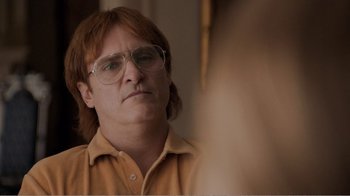 Movie still from “Don't Worry, He Won't Get Far on Foot” (2018), directed by Gus Van Sant – A man with long red hair wearing glasses and an orange shirt; Close Up shot, Over the shoulder angle