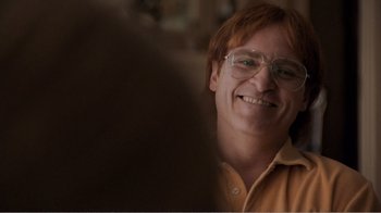 Movie still from “Don't Worry, He Won't Get Far on Foot” (2018), directed by Gus Van Sant – A person wearing glasses and smiling; Close Up shot, Low angle
