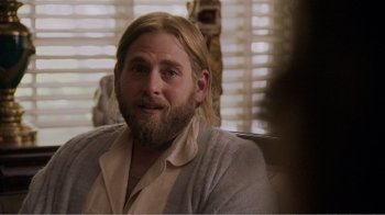 Movie still from “Don't Worry, He Won't Get Far on Foot” (2018), directed by Gus Van Sant – A man with long blonde hair sitting in front of a window; Close Up shot, Over the shoulder angle