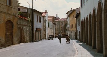 Movie still from “Life Is Beautiful” (1997), directed by Roberto Benigni – People walking down a street in a small town; Extreme Wide shot, High angle