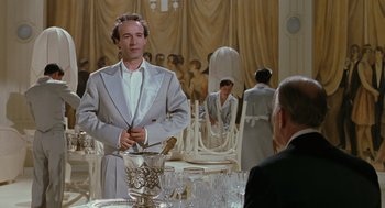 Movie still from “Life Is Beautiful” (1997), directed by Roberto Benigni – A man standing in front of a bunch of chairs; Medium shot, Low angle