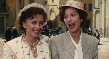 Movie still from “Life Is Beautiful” (1997), directed by Roberto Benigni – A couple of women standing next to each other on a street; Close Up shot, Low angle