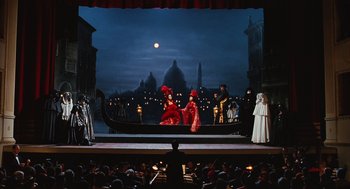 Movie still from “Life Is Beautiful” (1997), directed by Roberto Benigni – A scene of a scene in a theater with people dressed in costumes; Extreme Wide shot, High angle