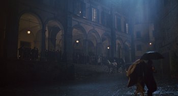 Movie still from “Life Is Beautiful” (1997), directed by Roberto Benigni – A group of people riding horses down a street at night; Extreme Wide shot, Over the shoulder angle