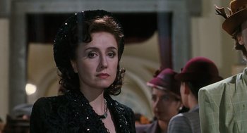 Movie still from “Life Is Beautiful” (1997), directed by Roberto Benigni – A woman wearing a black dress and a hat; Close Up shot, Over the shoulder angle