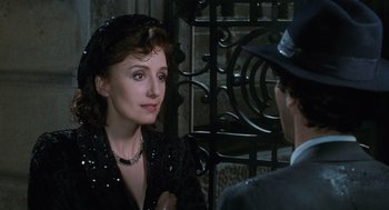 Movie still from “Life Is Beautiful” (1997), directed by Roberto Benigni – A woman wearing a black sequined dress and a hat; Close Up shot, Over the shoulder angle