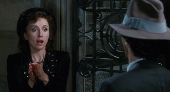 Movie still from “Life Is Beautiful” (1997), directed by Roberto Benigni – A woman talking to a man wearing a suit and hat; Close Up shot, Over the shoulder angle