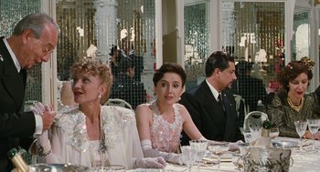 Movie still from “Life Is Beautiful” (1997), directed by Roberto Benigni – A group of people sitting at a dinner table; Medium shot, Over the shoulder angle