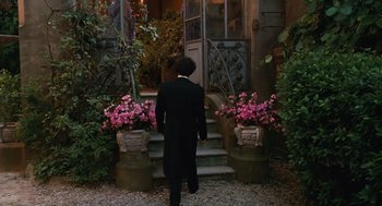 Movie still from “Life Is Beautiful” (1997), directed by Roberto Benigni – A man in a tuxedo walking down the steps of a house; Wide shot, High angle