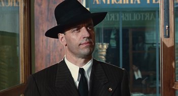 Movie still from “Life Is Beautiful” (1997), directed by Roberto Benigni – A man wearing a suit and a black hat; Close Up shot, Low angle