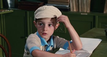 Movie still from “Life Is Beautiful” (1997), directed by Roberto Benigni – A young boy wearing a hat is writing with a pencil; Close Up shot, High angle