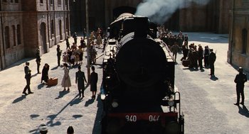 Movie still from “Life Is Beautiful” (1997), directed by Roberto Benigni – A train traveling down train tracks next to a crowd of onlookers; Extreme Wide shot, High angle