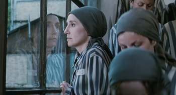 Movie still from “Life Is Beautiful” (1997), directed by Roberto Benigni – A woman in a prison uniform looking out of a window; Close Up shot, Over the shoulder angle
