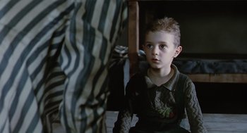 Movie still from “Life Is Beautiful” (1997), directed by Roberto Benigni – A young boy sitting in front of an older man; Medium shot, Over the shoulder angle