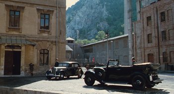 Movie still from “Life Is Beautiful” (1997), directed by Roberto Benigni – An old car parked on the side of the road; Extreme Wide shot, High angle