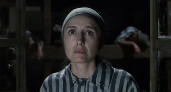 Movie still from “Life Is Beautiful” (1997), directed by Roberto Benigni – A woman in a striped shirt and a hat looking up; Close Up shot, Over the shoulder angle