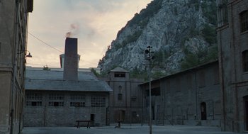 Movie still from “Life Is Beautiful” (1997), directed by Roberto Benigni – An old building with a clock tower in the middle of it; Extreme Wide shot, Low angle