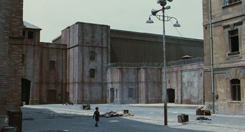 Movie still from “Life Is Beautiful” (1997), directed by Roberto Benigni – A person standing in front of an old building; Extreme Wide shot, High angle