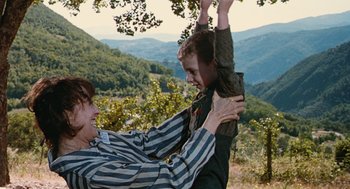 Movie still from “Life Is Beautiful” (1997), directed by Roberto Benigni – A man and a boy are playing in the mountains; Medium shot, Low angle