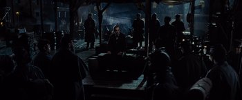 Movie still from “Lincoln” (2012), directed by Steven Spielberg – A group of people standing around in the dark; Wide shot, Over the shoulder angle