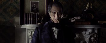 Movie still from “Lincoln” (2012), directed by Steven Spielberg – An old man wearing a suit and tie smoking a cigarette; Close Up shot, Low angle