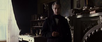 Movie still from “Lincoln” (2012), directed by Steven Spielberg – An older man in a black coat and a black bow tie; Medium shot, Low angle