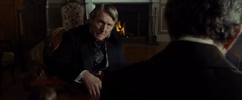 Movie still from “Lincoln” (2012), directed by Steven Spielberg – An older man sitting in front of a fireplace; Medium shot, Over the shoulder angle