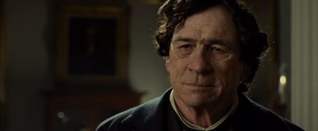 Movie still from “Lincoln” (2012), directed by Steven Spielberg – An older man wearing a suit and tie; Close Up shot, Over the shoulder angle