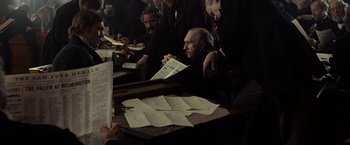 Movie still from “Lincoln” (2012), directed by Steven Spielberg – A group of people sitting at a table reading papers; Medium shot, High angle