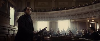 Movie still from “Lincoln” (2012), directed by Steven Spielberg – A man standing in front of an audience in a courtroom; Medium shot, Low angle